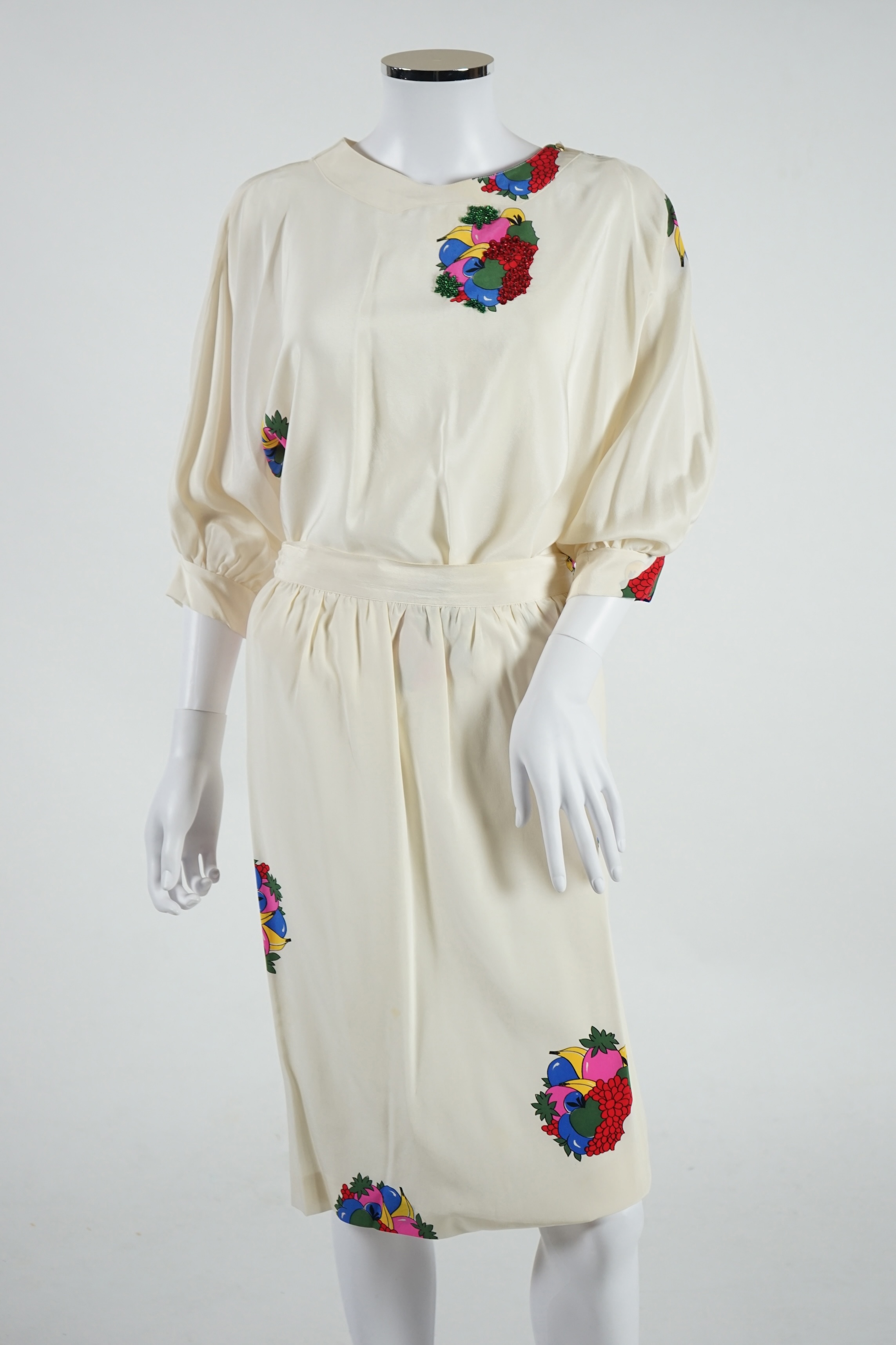 A lady's Angela Caputi silk cream skirt and blouse with fruit design size 46, a Ted Baker white lightweight cardigan with leaf design to the back size 4, a Rawhide dusky pink long laser cut coat size 14 and a Georgina vo